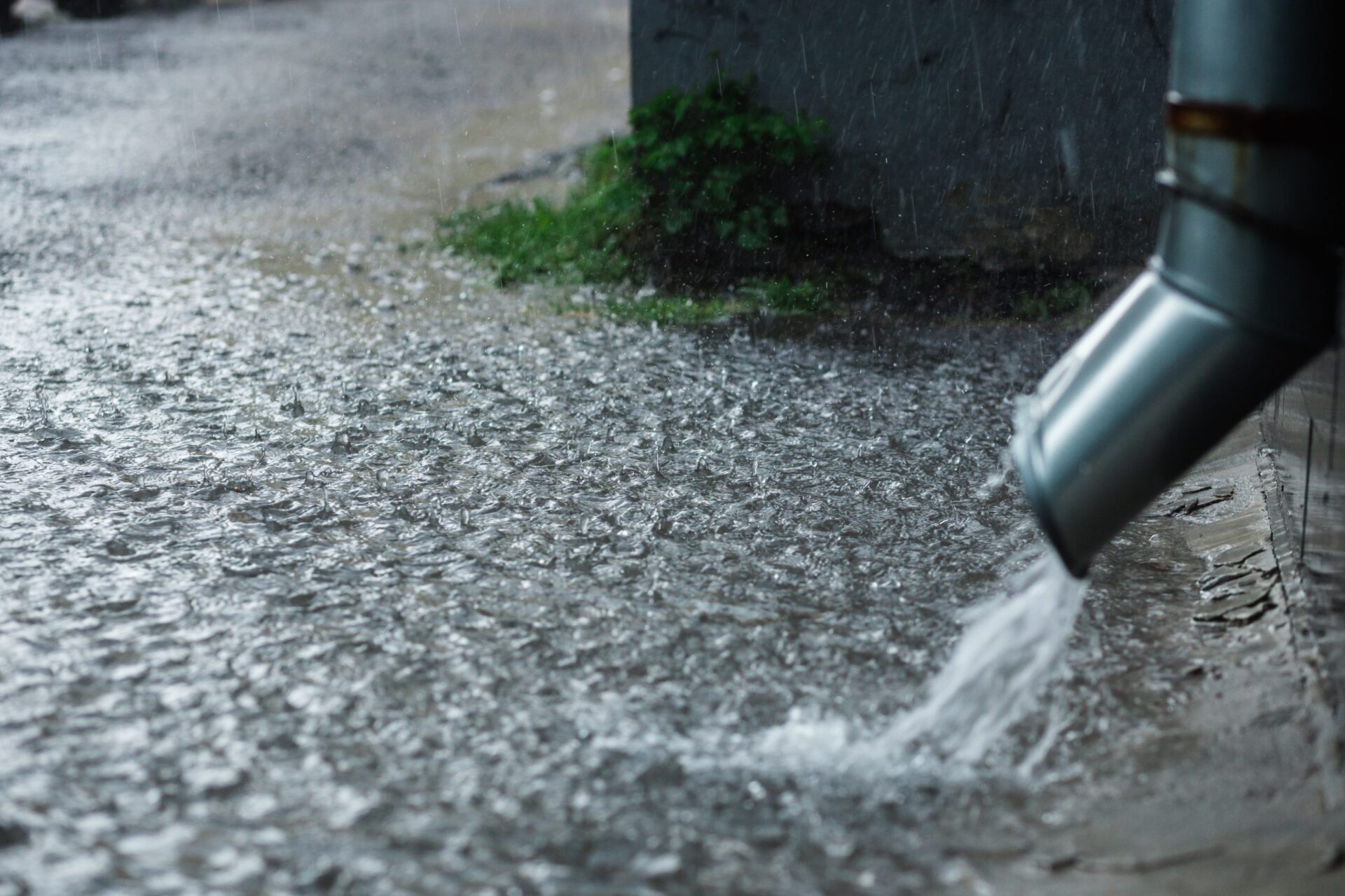 Heavy rain flowing from a downspout during a heavy rain can cause sewer line clog. Midcity Plumbers