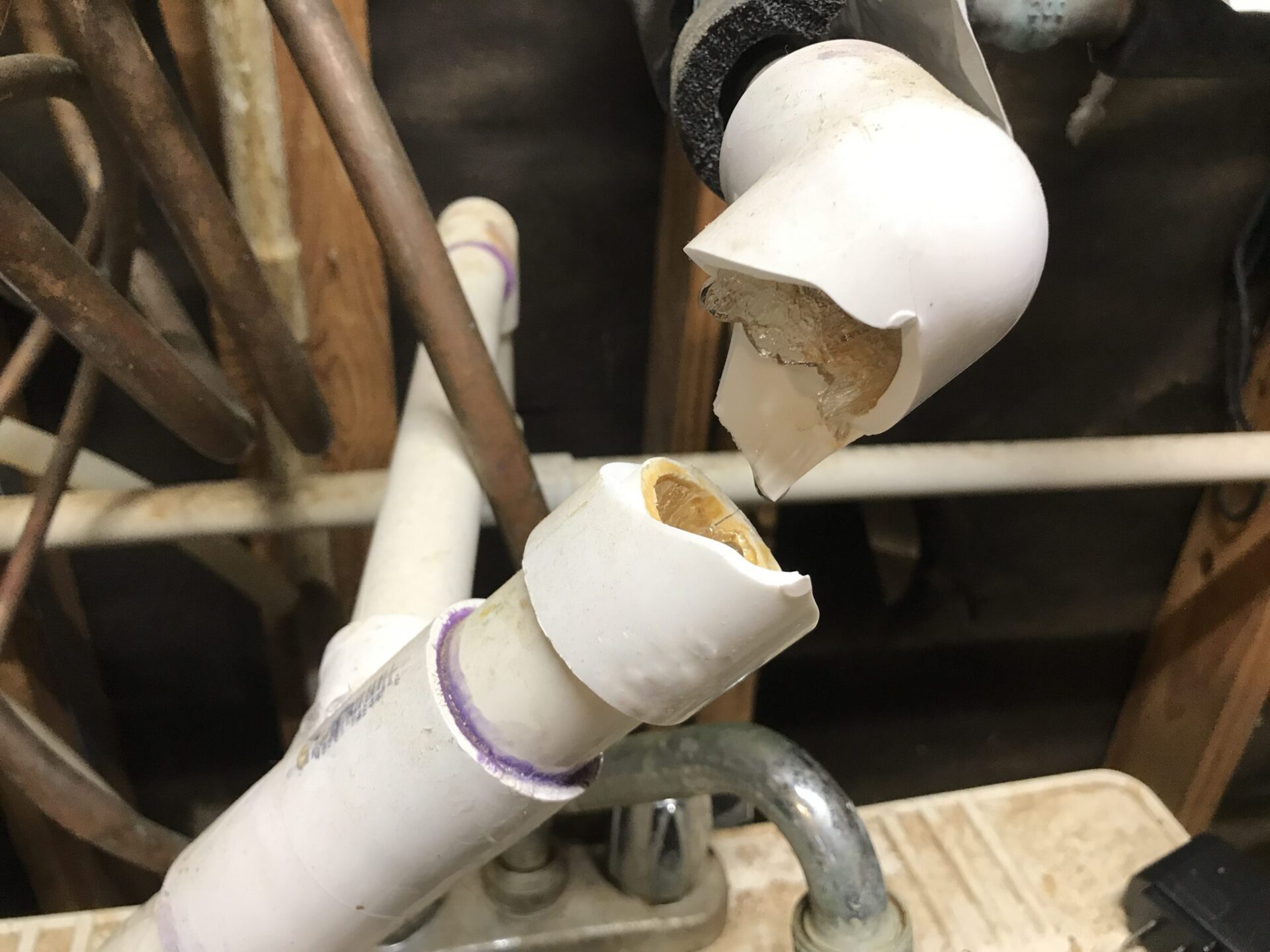 Busted plumbing water pipe with ice frozen and water dripping