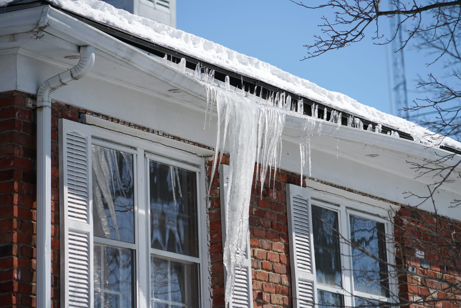 Icicle on the house roof in winter season during cold snap. MidCity Plumbers