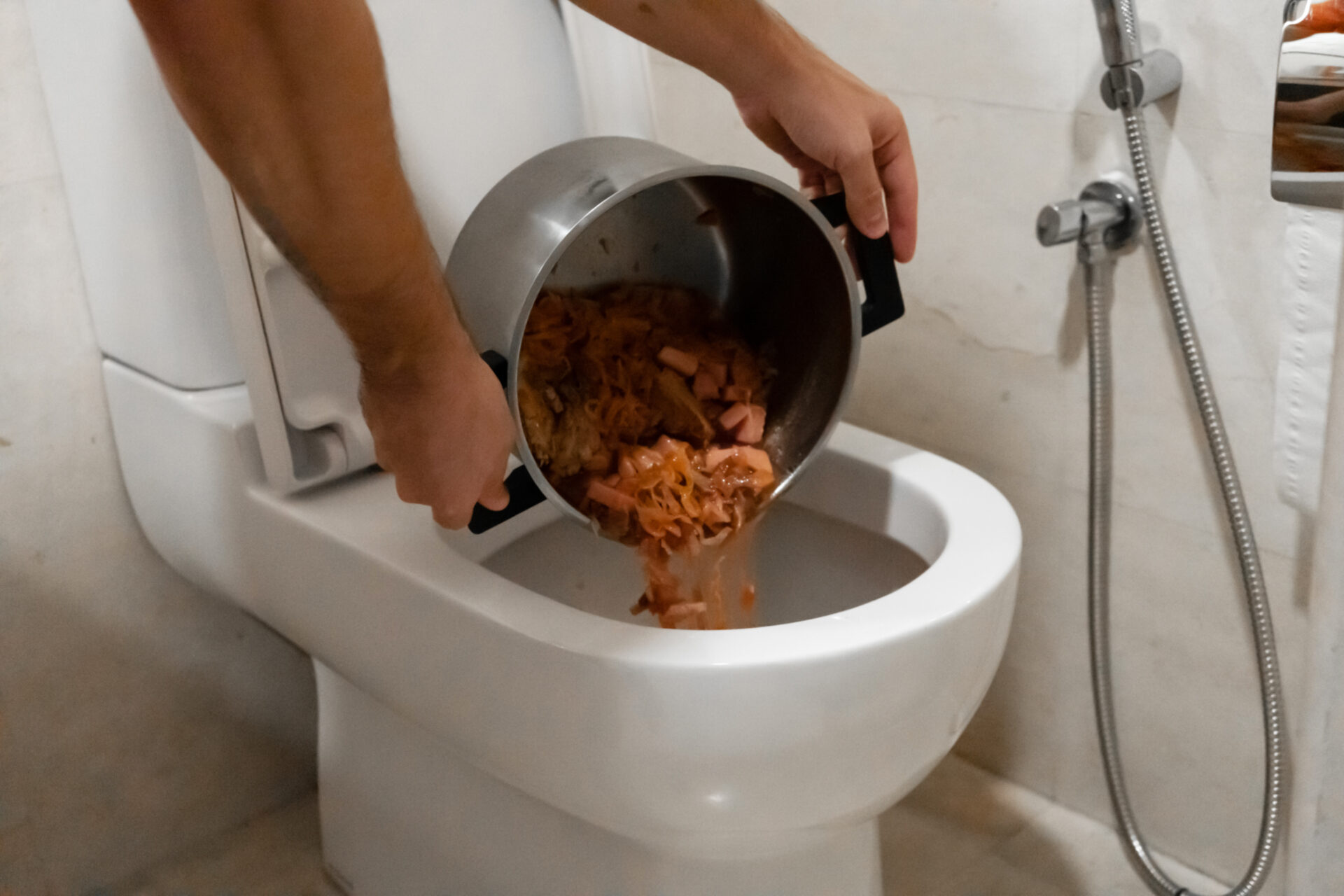 Person pours a pot of soup into the toilet which can cause clogs. MidCity Plumbers