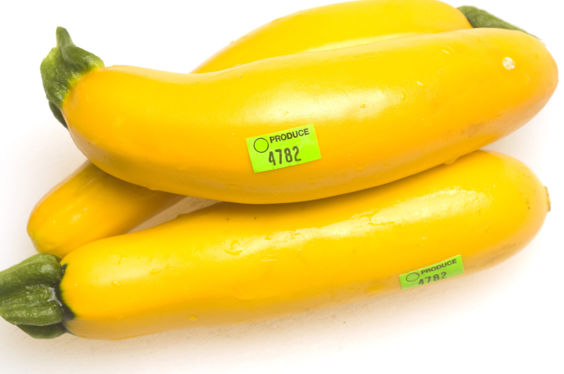 Three yellow zucchini with produce stickers. Avoid disposing in kitchen drain. MidCity Plumbers