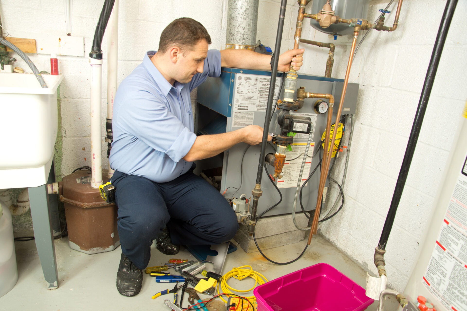 Plumber repairs and maintains gas furnace. MidCity Plumbers